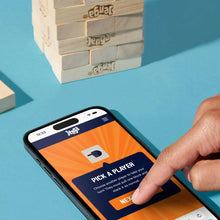 Light wood tower blocks beside a smartphone showing the game app screen