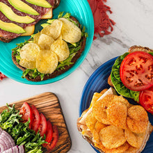 Assorted tortilla chips with guacamole, salsa, and tomato slices on plates