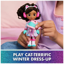 Sweetest Treat Gabby doll held in a hand, cat-ear hood and pink earmuffs