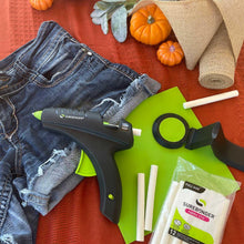 Black and green hot melt glue gun with green glue sticks and storage bag