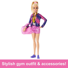 Blonde gymnast doll wearing a purple and pink leotard with a pink gym bag