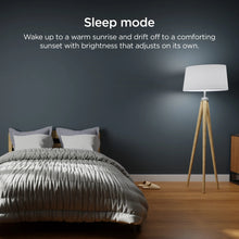 Smart LED bulb in a tripod floor lamp, warm light in a bedroom