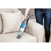 BISSELL handheld vacuum with upholstery nozzle, cleaning a couch cushion