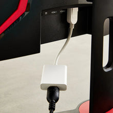 White DisplayPort to HDMI adapter connected to a monitor HDMI port