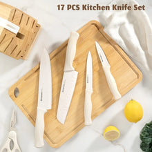 Kitchen knife set with white-handled knives and wooden knife block on countertop