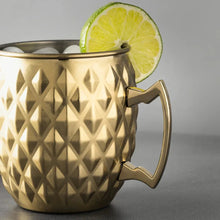 Gold stainless steel Moscow mule mug with diamond texture and lime wedge on rim
