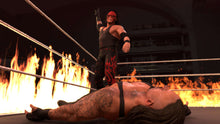 Wrestler in black-and-red gear posing on fire-lit ring mat