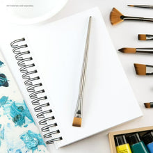 Mixed media paper pad with spiral binding, blank pages and artist brushes nearby
