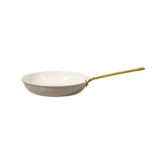 Nonstick frying pan in light taupe with gold handle and white cooking surface