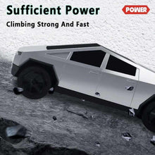 RC pickup truck with LED light bar driving over rocky surface, gray body and black wheels.