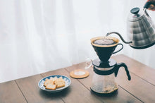Hario V60 pour over coffee starter set with V60 dripper on glass server and metal kettle