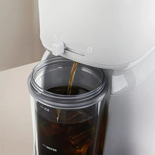 Single-serve iced coffee maker close-up pouring into a clear ice container