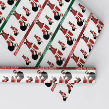 Close-up of Santa figure wrapping paper with red and green text bands, shown on a roll.