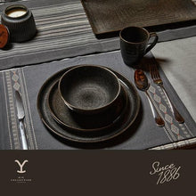 Black ceramic mug and nested bowls on a table setting