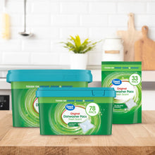 Dishwasher pacs containers on kitchen counter, teal lids, green tubs, fresh scent