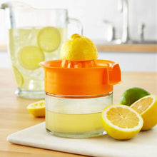 Orange citrus juicer on cutting board with lemon and lime wedges