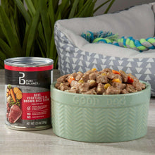 Wet dog food can beside bowl of beef stew with carrots and vegetables