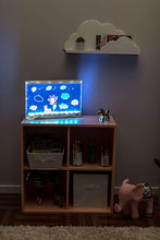 LED light board on a shelf, displaying blue floral tracing artwork