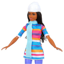 Ice skating fashion doll close-up in blue striped dress with white hat