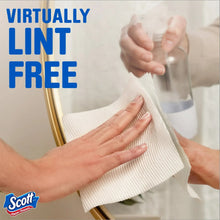 White Scott paper towel sheet held in hands for lint-free cleaning