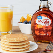 Maple syrup bottle with Great Value label, beside pancakes and fruit