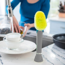 Dish wand standing on counter with yellow foam sponge for scrubbing