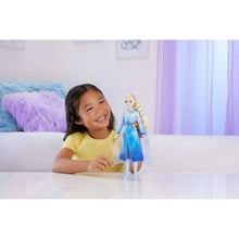 Elsa fashion doll in purple-blue dress standing next to a child at play