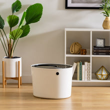 White round top-entry cat litter box with black scoop and circular opening