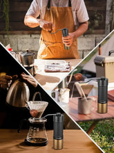 Manual coffee grinder held in a hand with black and gold body during brewing