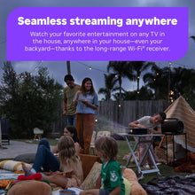 Family watching TV on patio while long-range Wi-Fi streaming device works