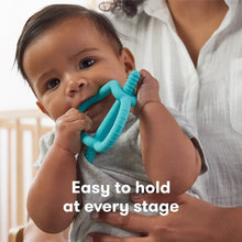 Teething ring toy in baby’s hands, teal-blue flexible grips and teething nub