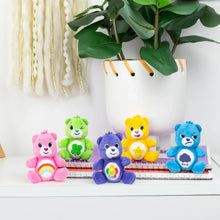 Five micro plush Care Bears seated together with colorful belly symbols