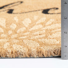 Coir doormat with floral design; ruler measures the mat edge height