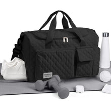 Black quilted travel duffel bag with front zip organizer, top carry handles, and shoulder strap