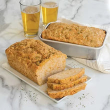 Natural aluminum loaf pans with two sliced herb bread loaves