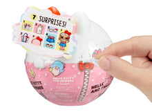 Pink surprise capsule toy with white bow and “7 surprises” play tag, held by hand