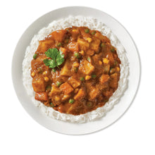 Vegetable tikka masala curry over rice in a white bowl