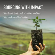 Hand holding a dark coffee bag with a sprout plant, Peet's