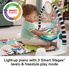 Blue baby playmat with piano toy panel, seated baby reaching at the front