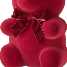 Red flocked bear decoration close-up with velvet bow and textured surface