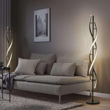 Modern spiral LED floor lamp with curved glowing light bars and standing base in living room