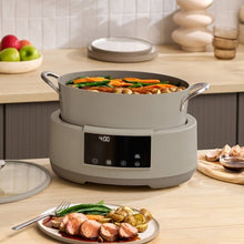 Beige multi-cooker with lid closed and front digital panel lit, ready-to-serve meal