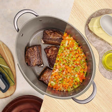 Beige multi-cooker pot with seared meat and chopped vegetables inside, lid removed
