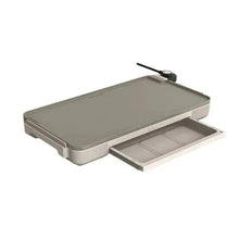 Electric griddle with open warming tray, gray cooking surface and side control.