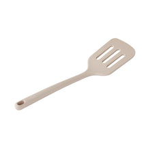 Beige slotted spatula with long handle and three cutout slots