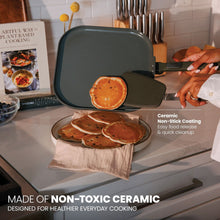 Moss green nonstick griddle pan with soft-touch handle, cooking pancakes