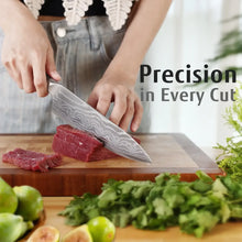 Chef knife with gray Damascus-pattern blade chopping red meat on a wooden cutting board
