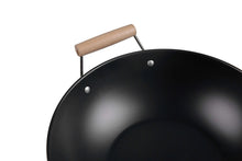 Wok rim close-up with wooden handle secured by metal support
