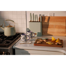 Mint green knife block with white-handled knives on a kitchen counter