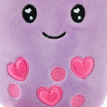 Close-up purple plush with stitched eyes, smile, and pink heart details